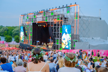 Women are watching concert at open air music festival