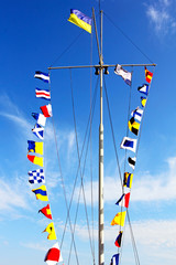 Marine signal flags on a mast in a port.