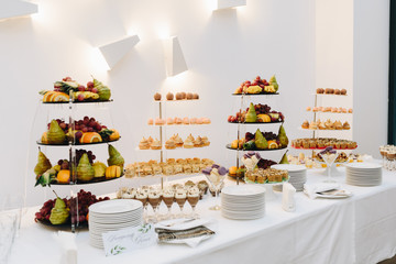 A banquet table with lots of fruit and desserts