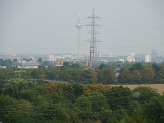 Frankfurter Fernsehturm Ginnheimer Spargel mit Strommast hinter diesigem Panorama von Hausen