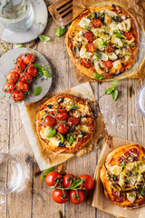 Fresh selfmade mini pizza on rustic wooden oak table 