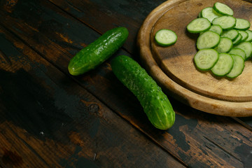 Whole and sliced cucumber on a wooden cutting board. Cucumber slices.