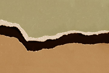 ragged edge of colored paper ocher on black background, copy space, close-up, blank for designer