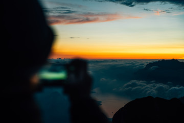 silhouette of person taking a photo with a smartphone