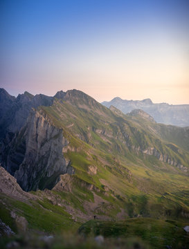 person with arms outspread in front of a mountain