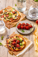 Fresh selfmade mini pizza on rustic wooden oak table 