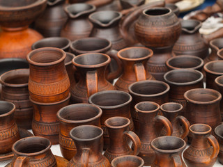 Handmade ceramic cups. Clay jugs and mug. Many ceramic utensil at the fair.