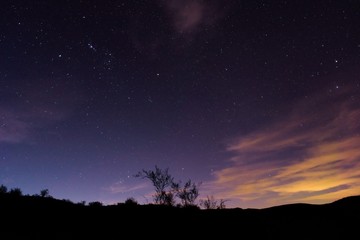 Fototapeta na wymiar Night sky above the desert in Lavalle, Mendoza, Argentina. Light pollution from the nearby city can be seen on the right side of the picture.