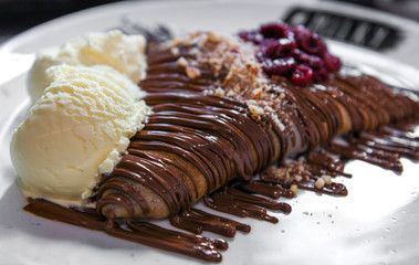 Pancake with cherries and chocolate cream served with vanilla ice cream