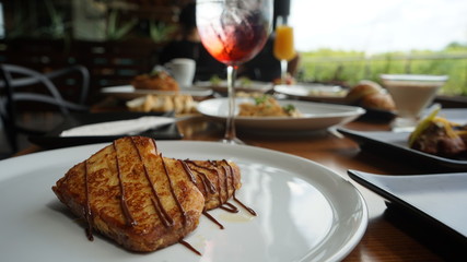 French toast on a white plate with orange juice