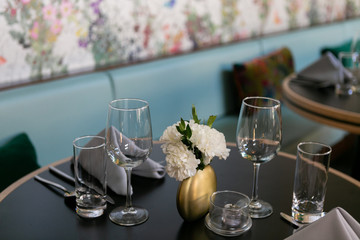 Nice table setting at restaurant with napkins, flowers, silverware, and wine glasses, trendy restaurant 