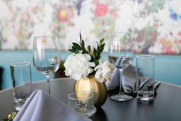 Nice table setting at restaurant with napkins, flowers, silverware, and wine glasses, trendy restaurant 