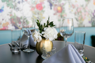 Nice table setting at restaurant with napkins, flowers, silverware, and wine glasses, trendy restaurant 
