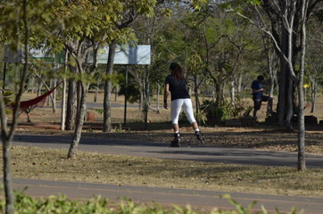 Fototapeta na wymiar A beautiful view of people walking with rollerblades in Brasilia park, Brazil