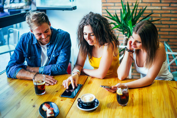 Three young friends having fun in restaurant