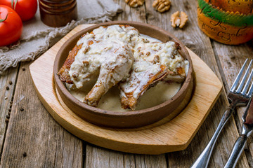 chicken chkmeruli in Georgian on wooden table.