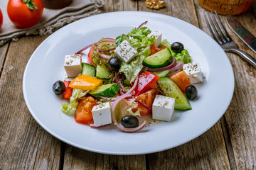 Greek salad with feta on wooden table