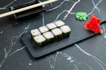 Maki roll with crab on dark marble table