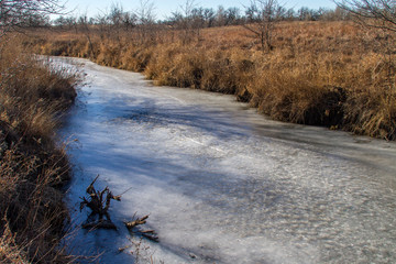 frozen stream through brown grass in rural Kansas