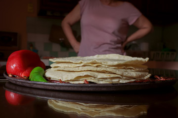 La cocinera acaba de poner las tortllas de maíz en la mesa.