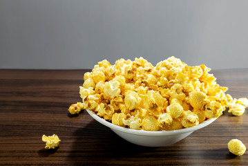 Popcorn in a bowl, placed on a wooden table