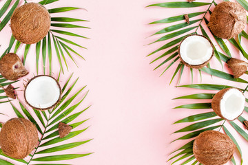 Pattern with coconuts and tropical palm leaves on pink background. Tropical abstract background. Flat lay, top view.