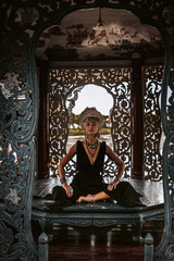 Obraz premium beautiful young woman in elegant black dress wearing turban. oriental princess