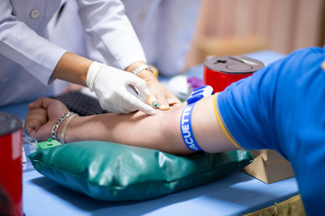 Thailand, Bangkok 2019/08/28. A health worker taking a blood sample from the vein by piercing the veinpunture and collecting blood into a test tube under negative pressure.
