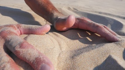 Sand in the hands of men. Close up view of sand running through a mans hands. Slow motion.