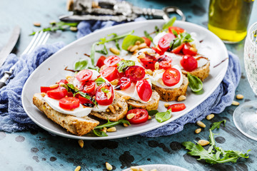 Italienisches Bruschetta mit gehackten Tomaten, Basilikum und Mozzarella auf gegrilltem knusprigem Brot
