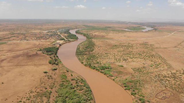 Drone flight towards Omorate town and bridge crossing the Omo river, near the border between Ethiopia (left) and Kenya (right)