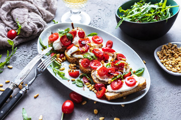 Italienisches Bruschetta mit gehackten Tomaten, Basilikum und Mozzarella auf gegrilltem knusprigem...