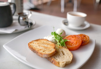 Healthy breakfast with poached eggs, tomatoes and toast bread