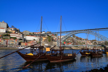 Fototapeta na wymiar Traditional rabelo boats, Porto city skyline, Douro river and and Dom Luis or Luiz iron bridge. Porto