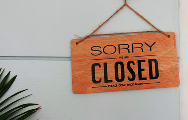 brown wooden signboard in front of wall