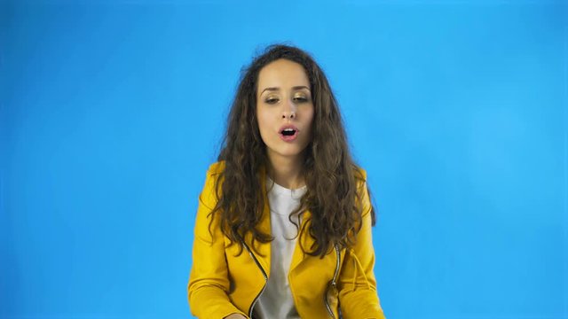 A woman feels pleasure close her eyes in Studio with blue Background.