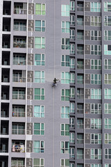 A painter was climbing the new building to painted on the facade of a high-rise building
