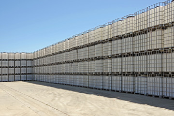 Fototapeta na wymiar Huge wall of large wine tanks in metal cages waiting for the wine harvest and production