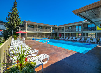 Fototapeta premium A hotel swimming pool with chaise-longues on side.