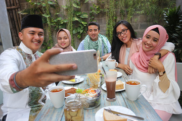 group of friends taking selfie during lunch outdoor