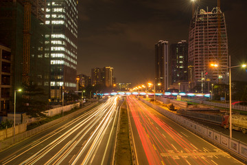 a long exposure shot on traffic light trails in downtown shenzhen at night