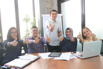 Young creative employees posing on camera in conference room. Company colleagues ready for open...