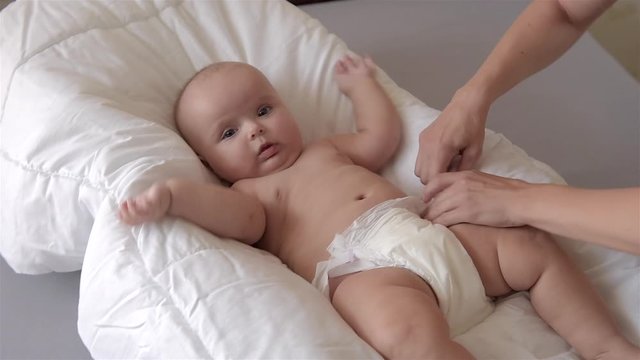 Mom changes the diaper to the baby. 