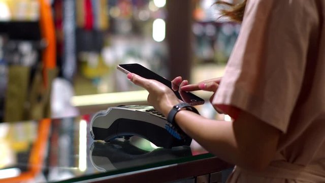 Young woman using smartphone to payment with credit transaction