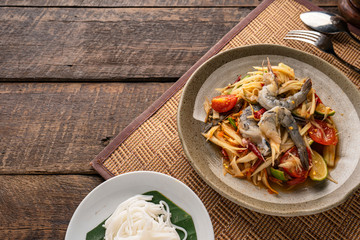 Thai papaya salad (Somtum) on table. Top view, free space for your message.