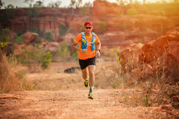 A man Runner of Trail and athlete's feet wearing sports shoes for trail running in the forest