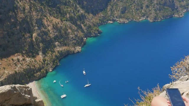 Woman traveller enjoying beautiful view of The Butterfly Valley from the top of the mountain