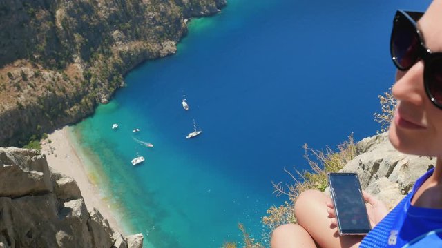 Woman traveller enjoying beautiful view of The Butterfly Valley from the top of the mountain