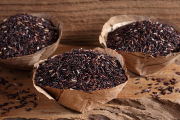 riceberry rice in wooden cup on wooden tray, riceberry rice in kitchen background