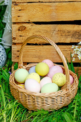 Wicker basket with Easter eggs in the garden.
